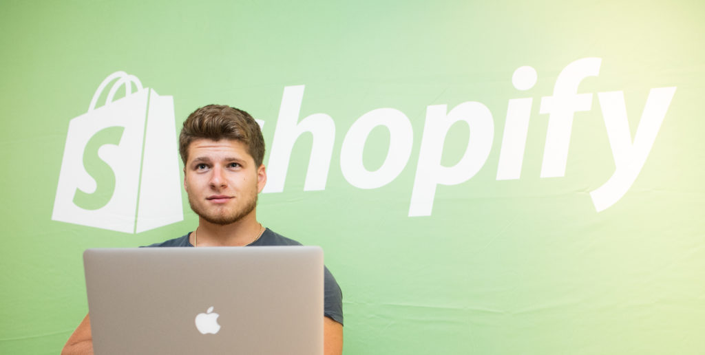 Justin Woll in front of a Shopify logo