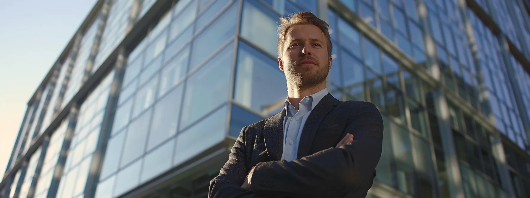 a confident justin woll standing in front of a sleek, modern office building, exuding success and ambition.